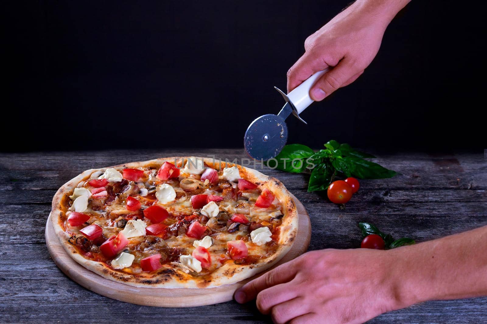 Delicious fresh Pizza with mozzarella, tomatoes, mushrooms, peppers and onion on the wooden background. Top view.