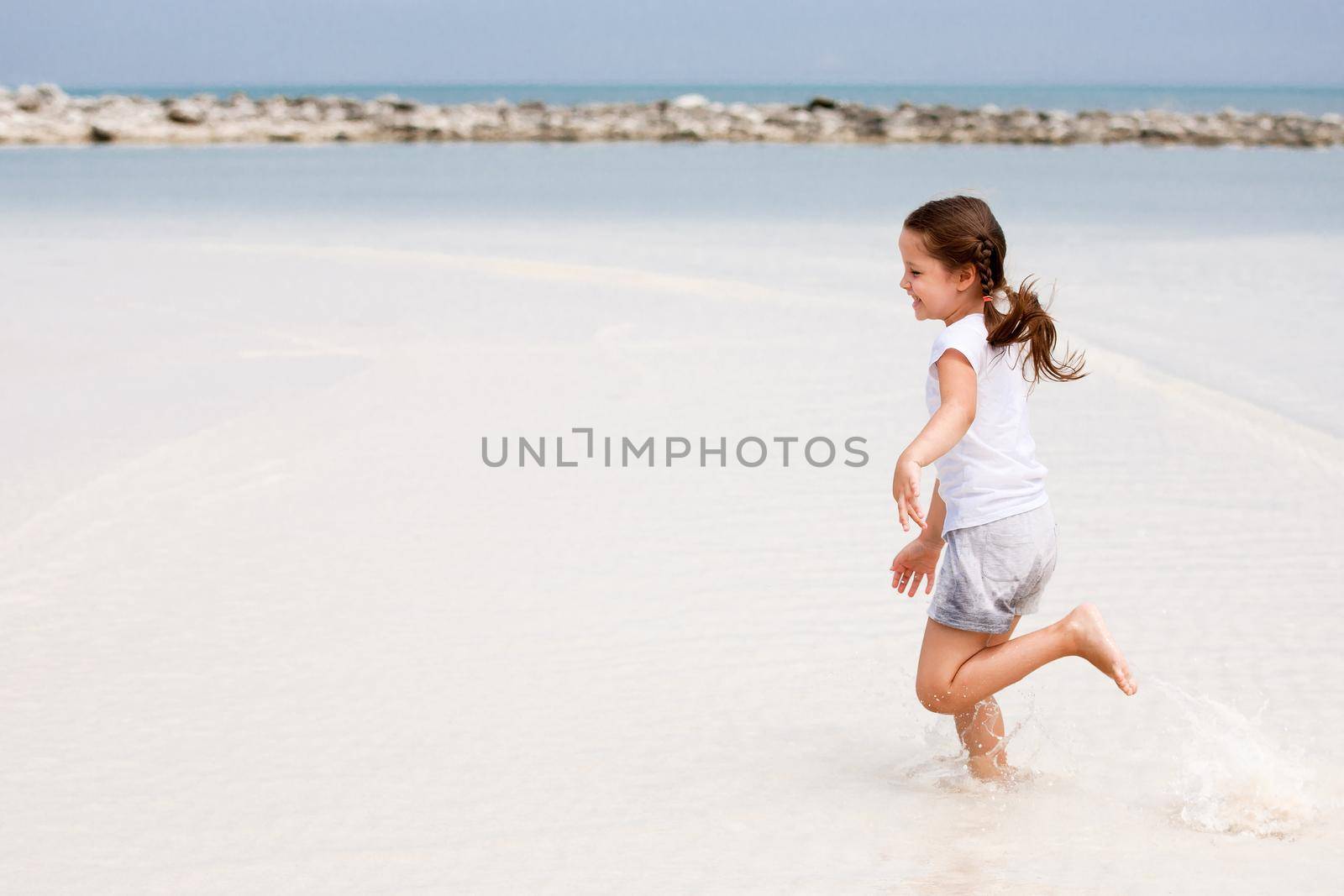 Adorable little girl have fun on the beach