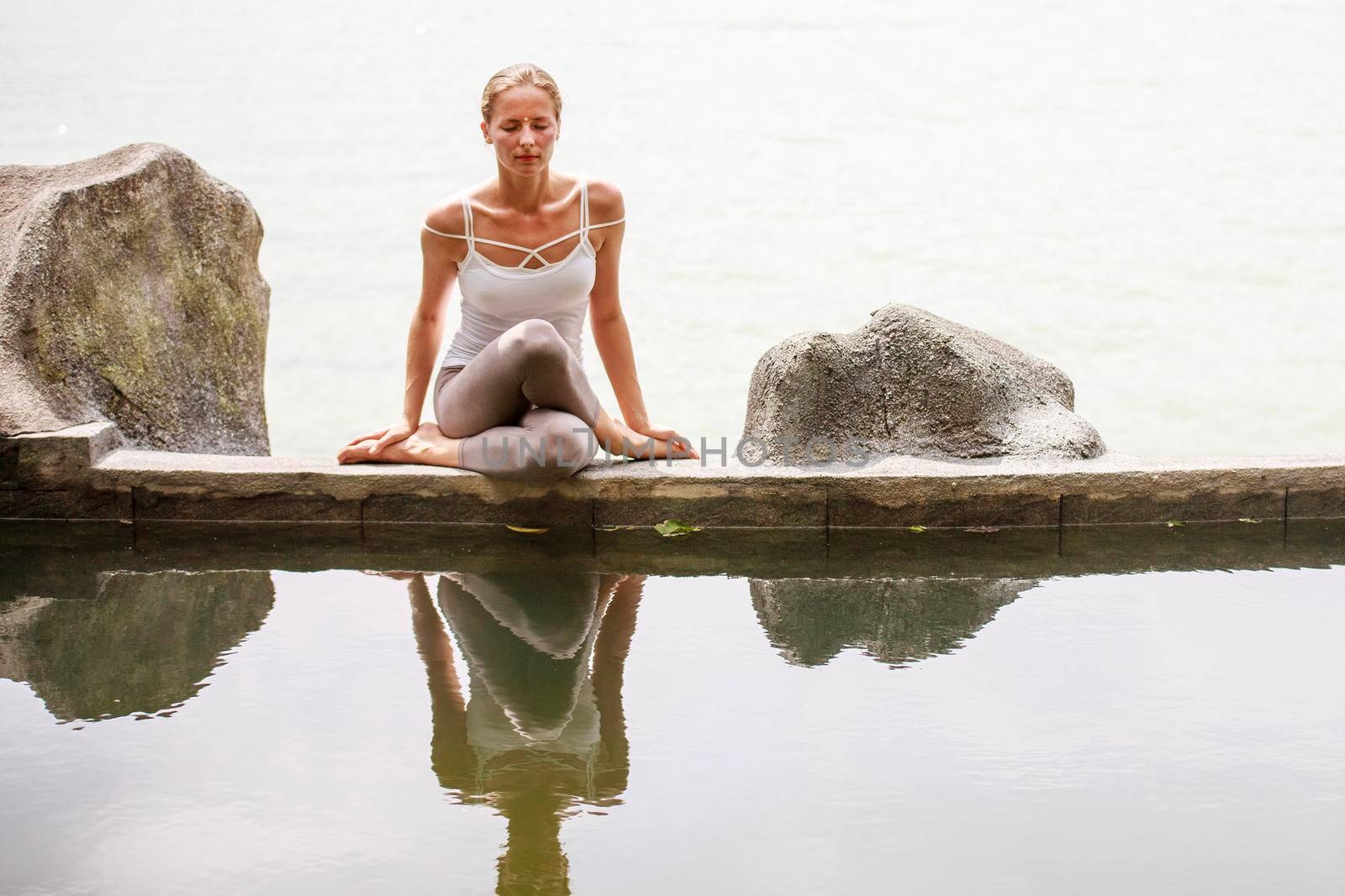 Woman practicing morning meditation Yoga at the beach by Jyliana