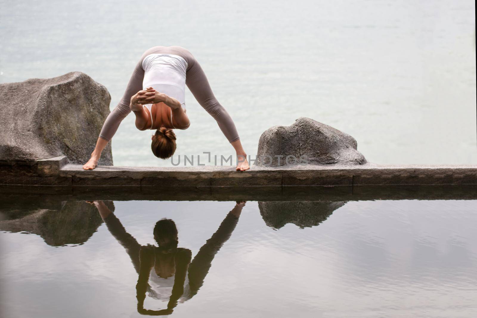 Woman practicing or doing morning meditation Yoga in nature at the beach