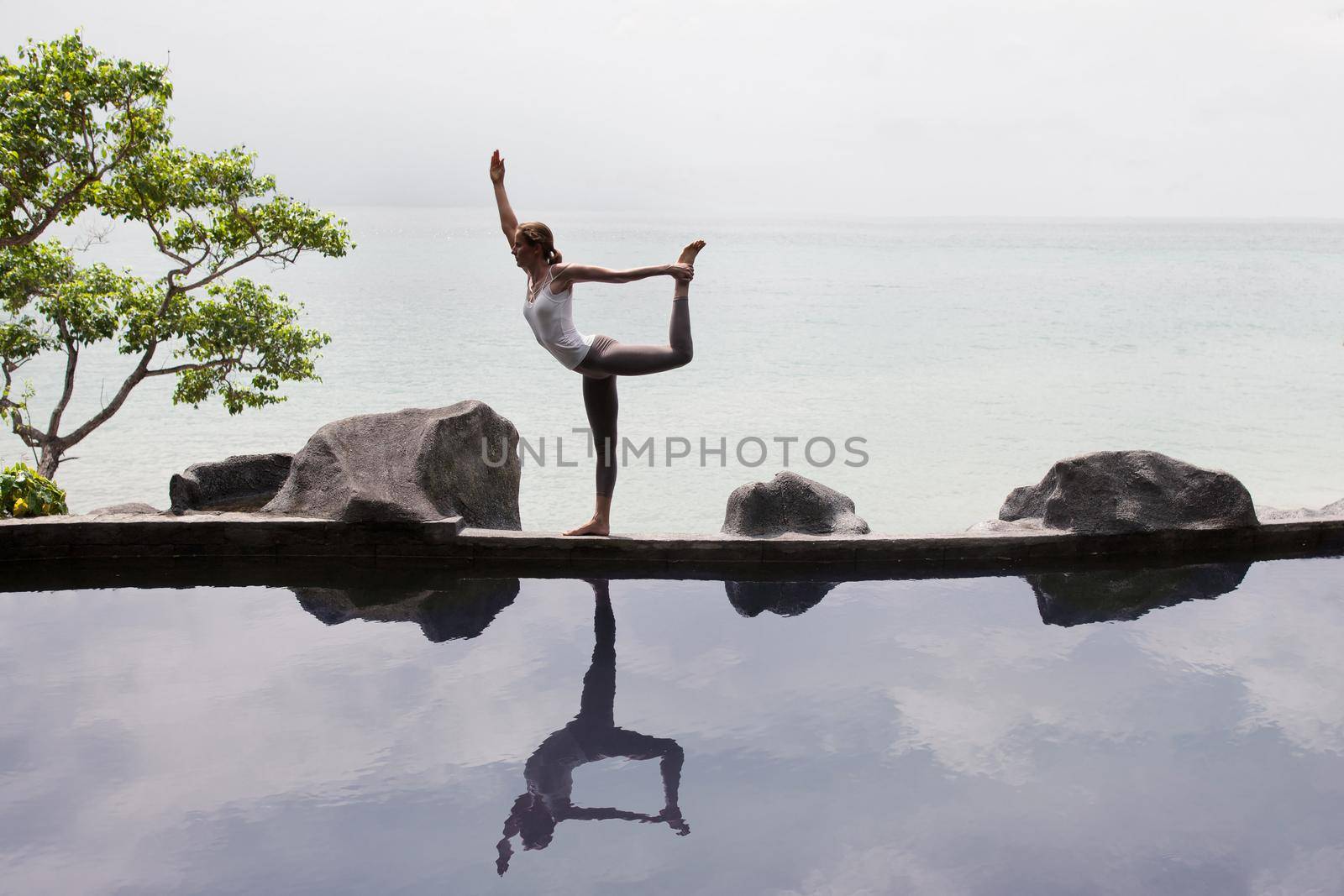 Woman practicing morning meditation Yoga at the beach by Jyliana