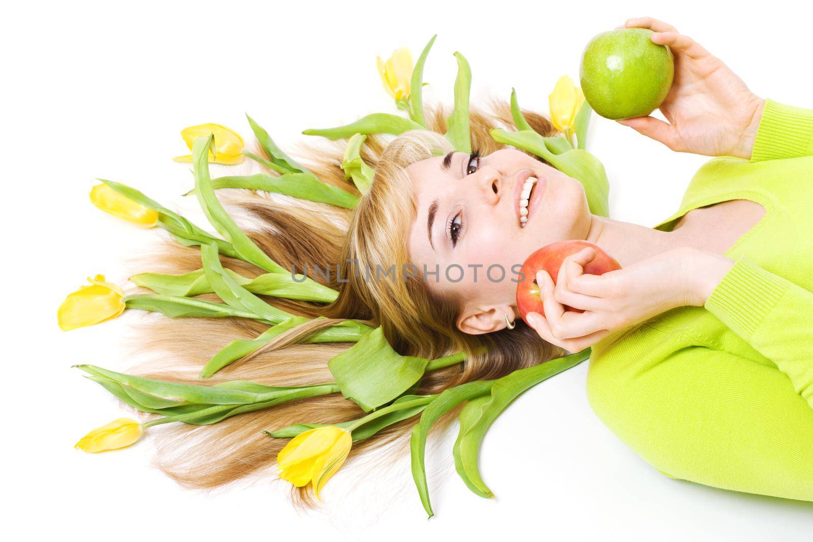 Smiling woman with apple and bouquet of tulips in her hair, isolated on white
