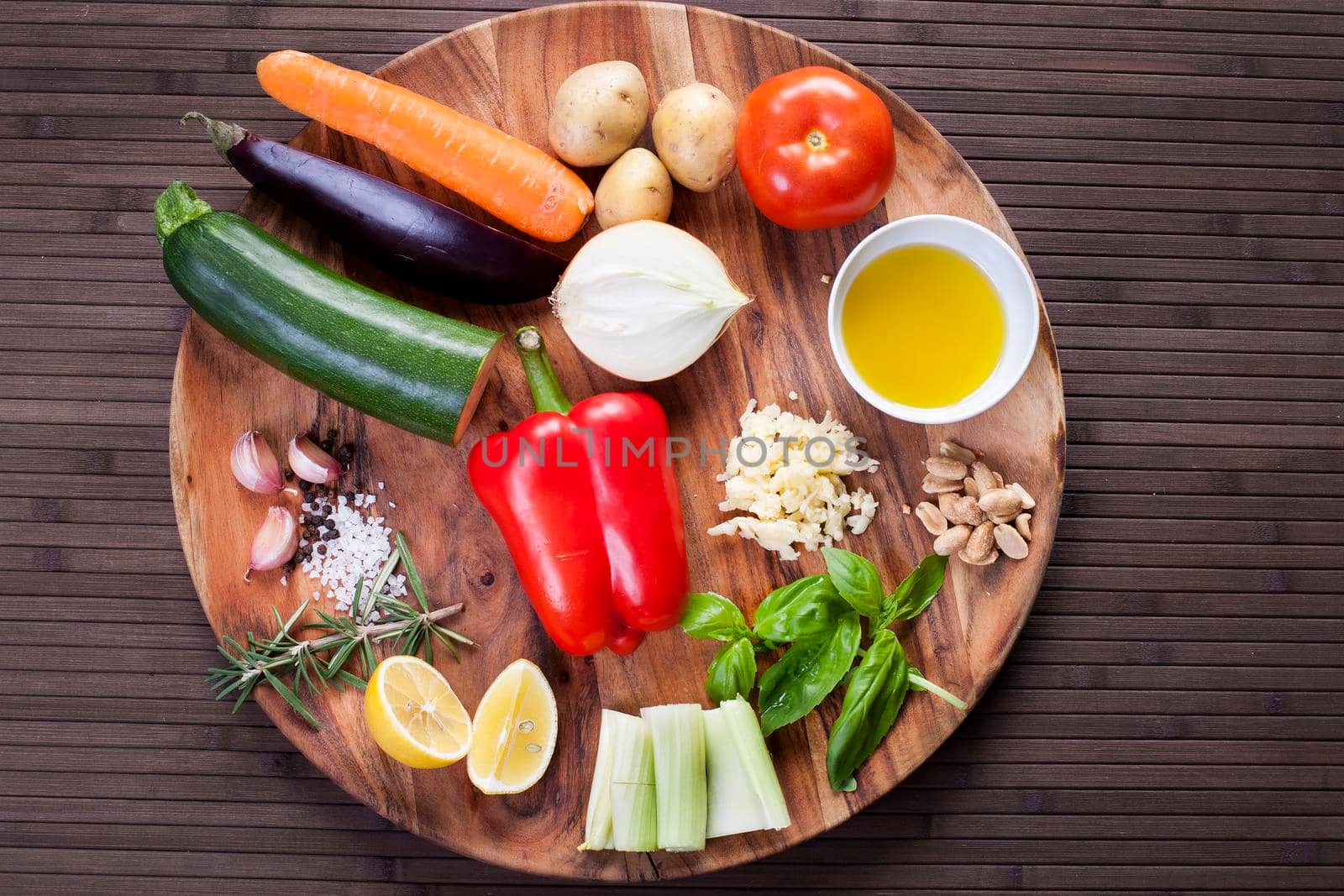 Ingredients vegetables for soup with pesto sauce and basil on a wooden plate. by Jyliana