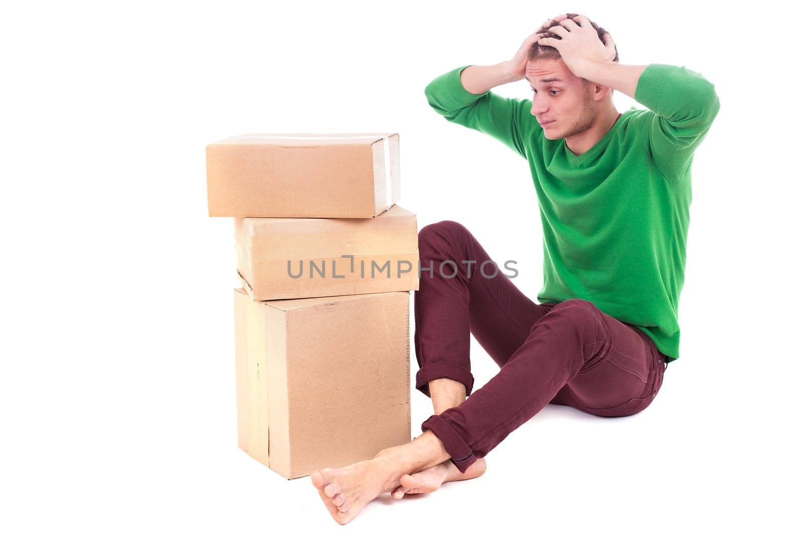 Sad, tired and surprised deliveryman hardly carries the parcel, isolated, white background