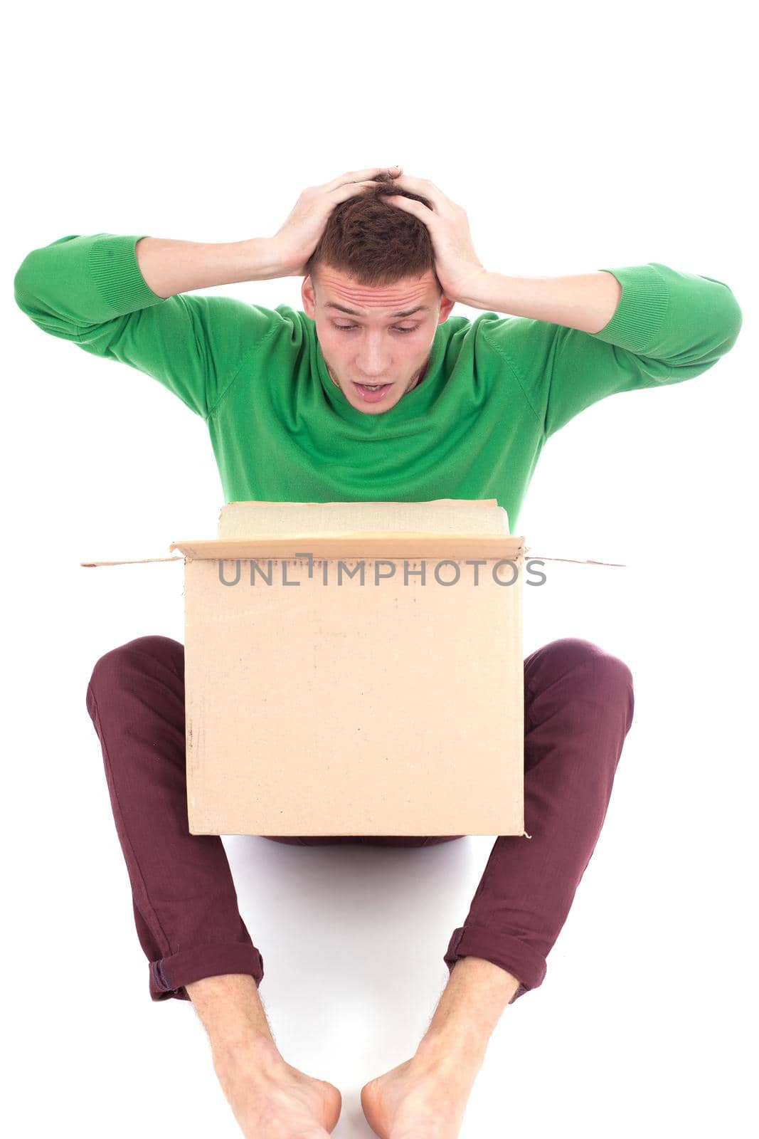 Sad, tired and surprised deliveryman hardly carries the parcel, isolated, white background