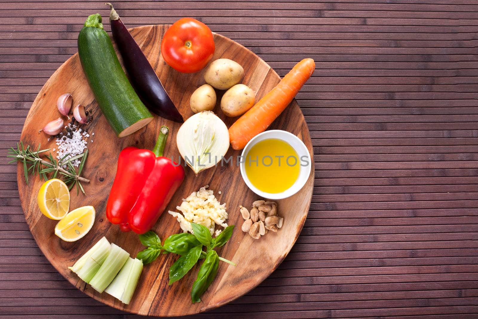 Ingredients vegetables for soup with pesto sauce and basil on a wooden plate. by Jyliana