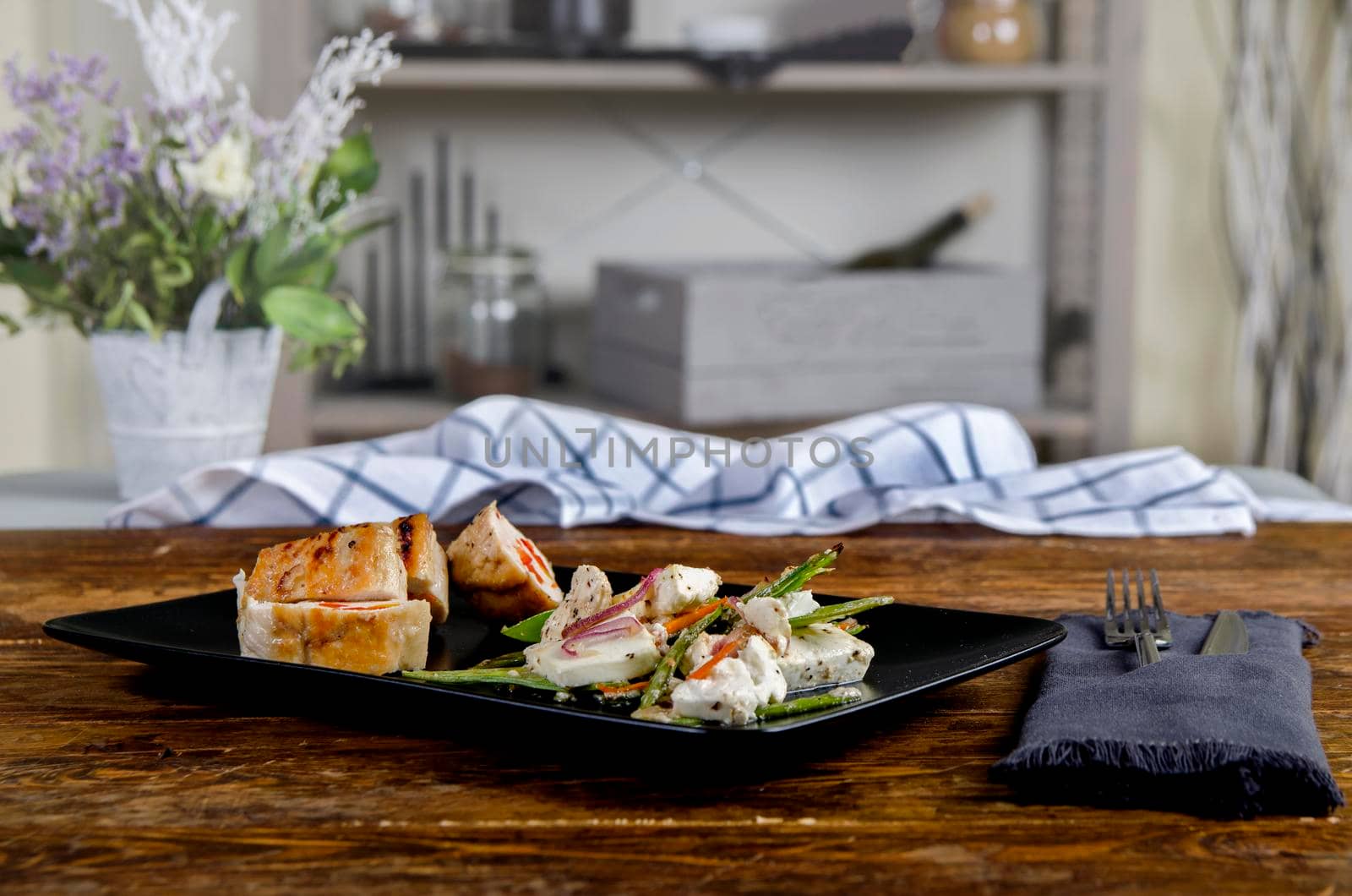 Stuffed turkey breast on the black plate snd wooden background. Chicken roulade - Stock image