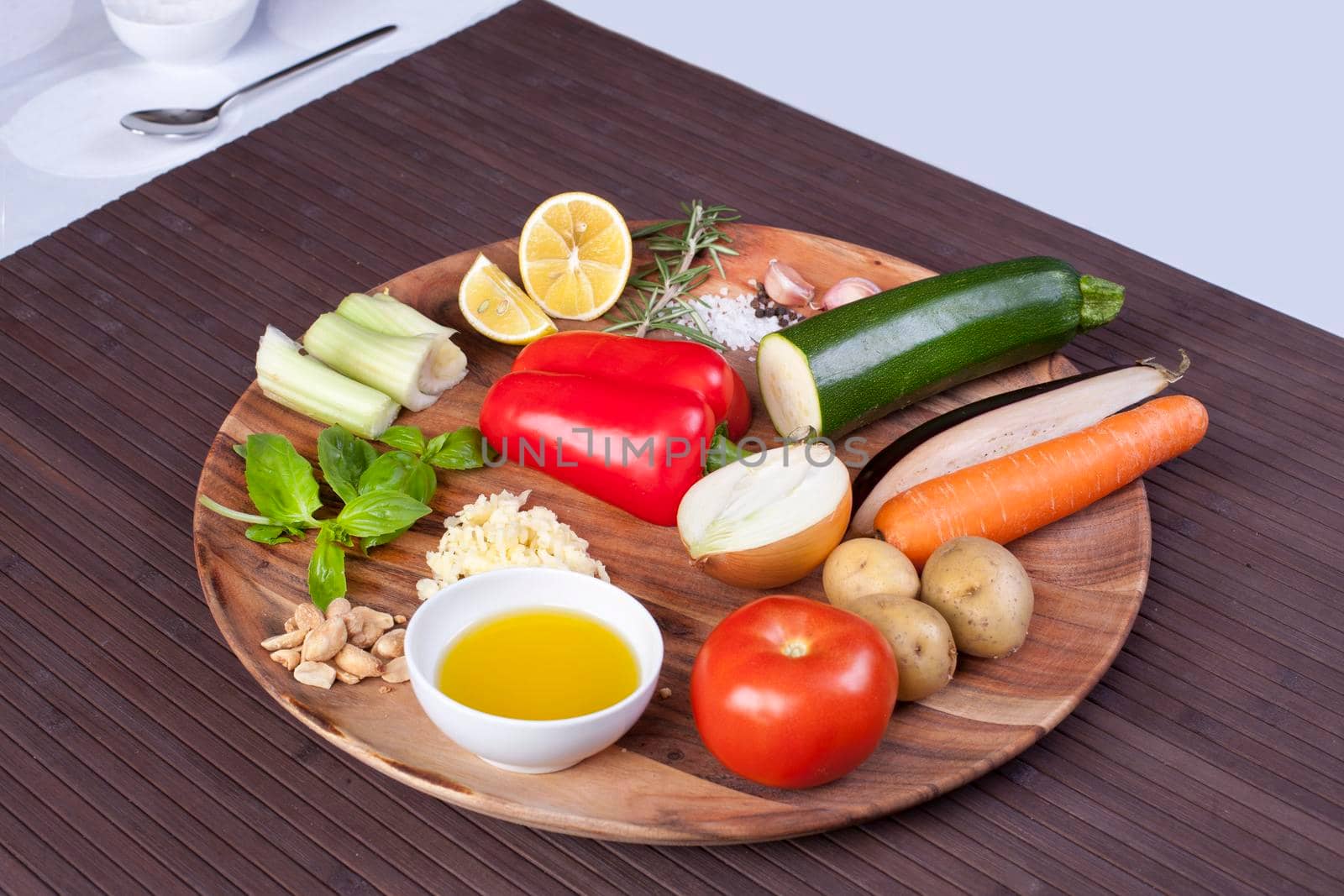 Ingredients vegetables for soup with pesto sauce and basil on a wooden plate. by Jyliana