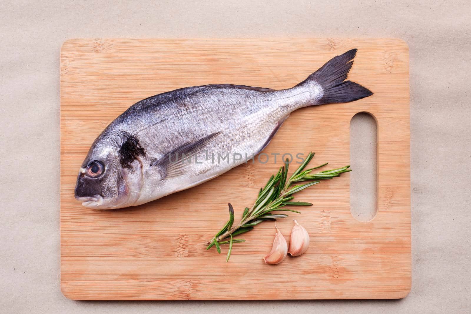 Fresh dorado fish seafood on wooden plank by Jyliana