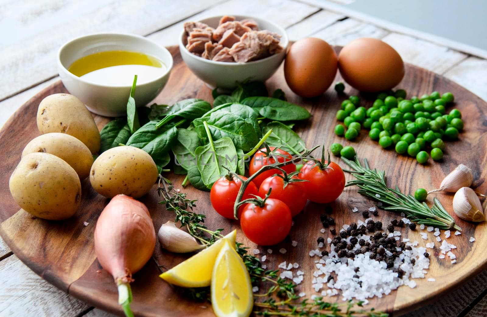 Ingredients. Tuna salad with lettuce, eggs and tomatoes on wooden plate