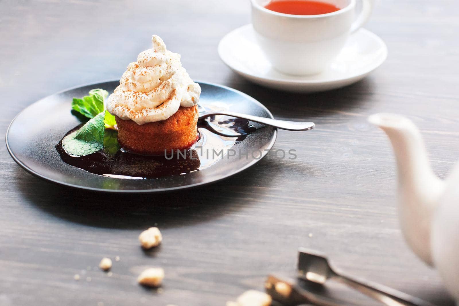 Breakfast time . Tea and cake with cream, garnished with mint leaves