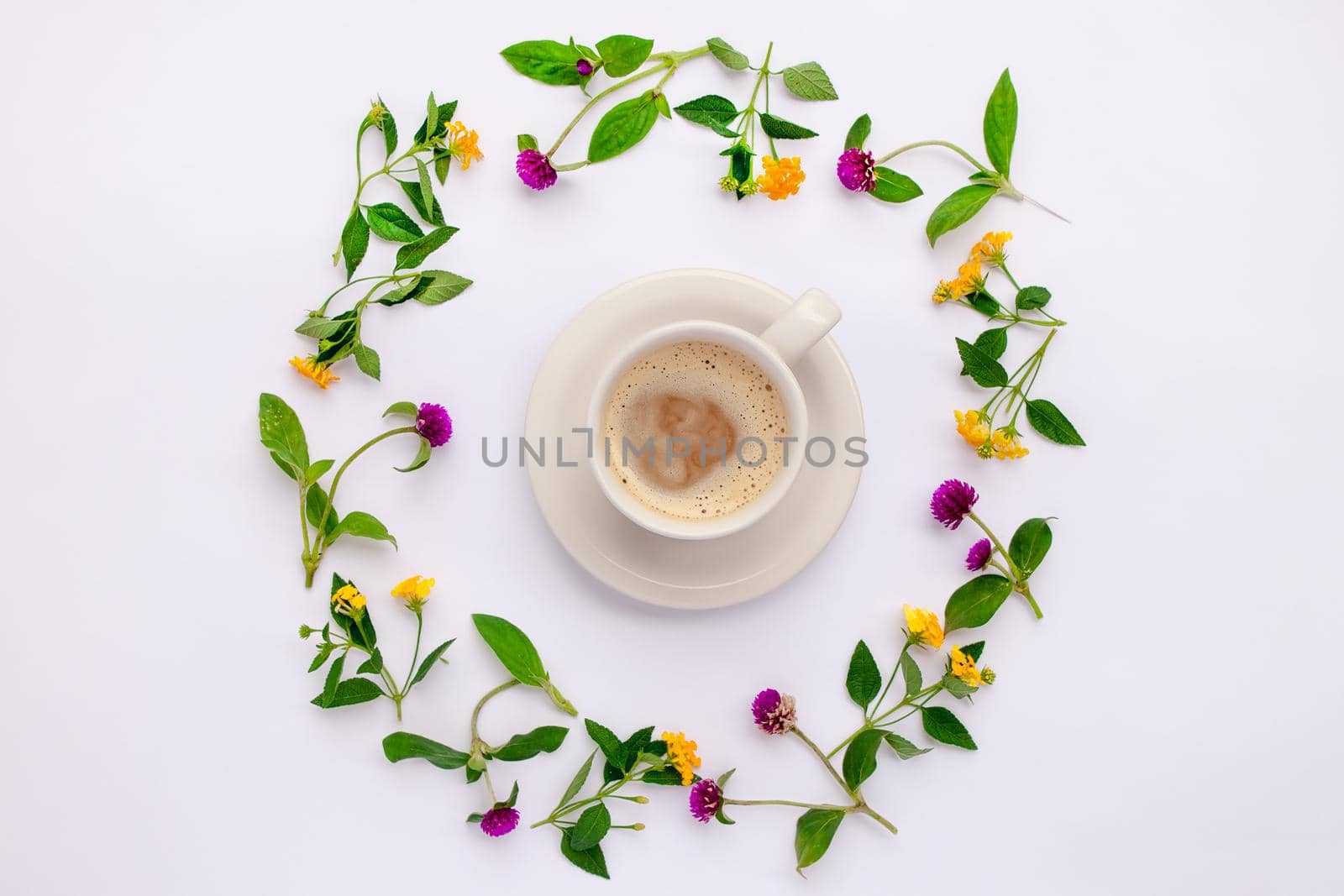 Meadow flowers and wildflowers arranged in circle with coffe cup. Flat lay.