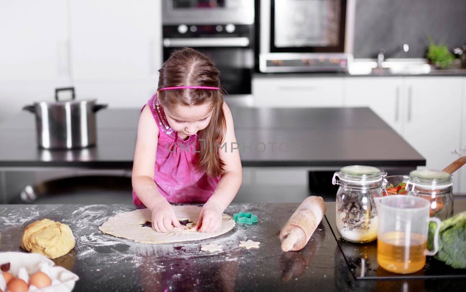 little cute girl is learning how to make cake, in kitchen, Family concept by Jyliana