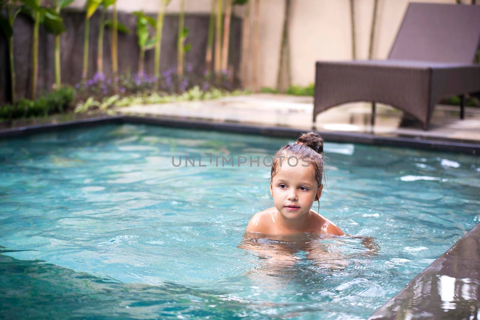 Happy Pretty little girl in swimming pool outdoor