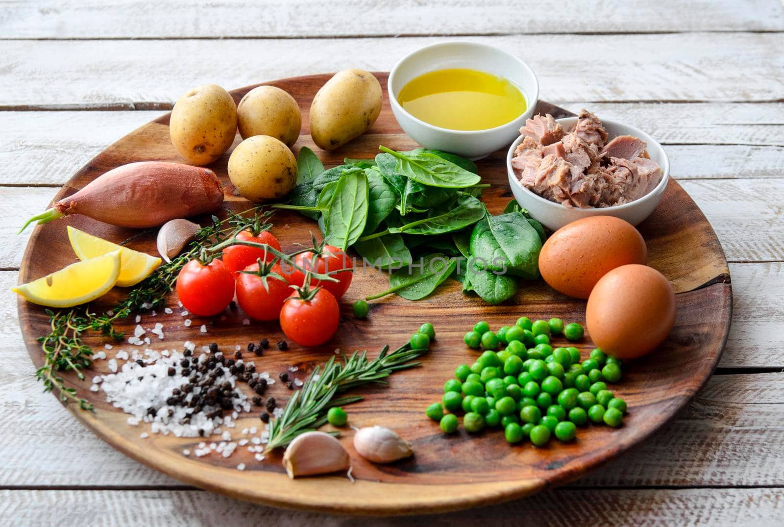 Ingredients. Tuna salad with lettuce, eggs and tomatoes on wooden plate