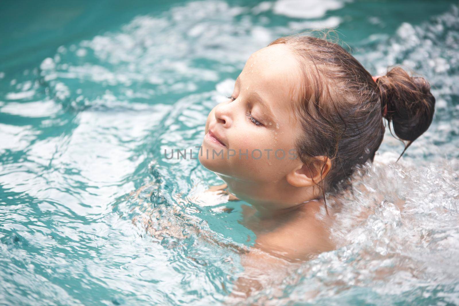 Happy Pretty little girl in swimming pool