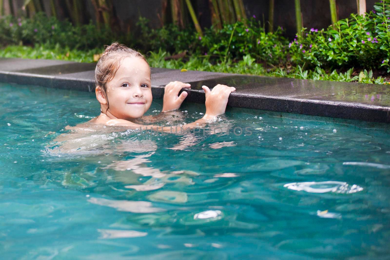 Happy Pretty little girl in swimming pool outdoor