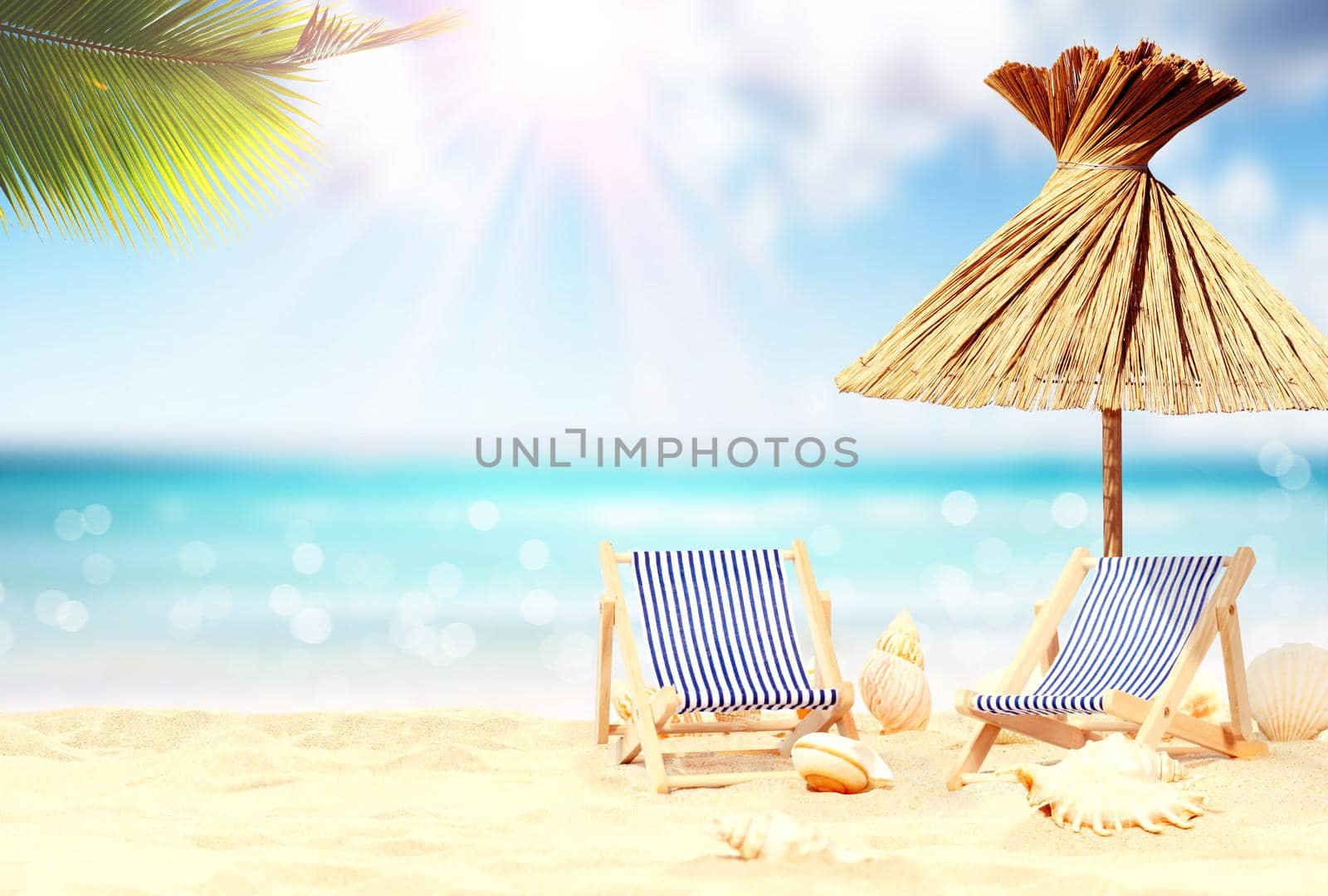 Relax on tropical beach in the sun on deck chairs under umbrella. by Taut