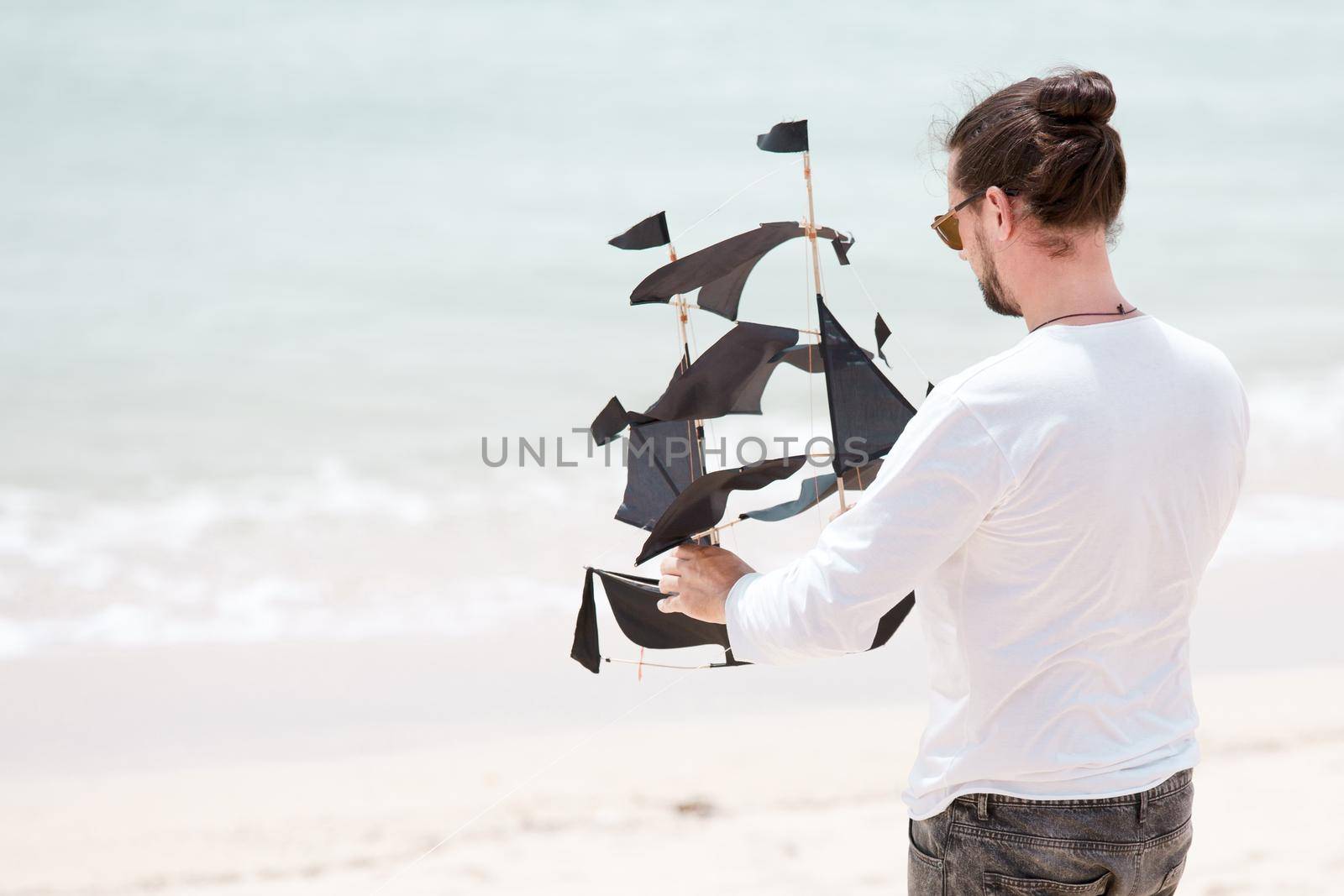 Happy man flying kite coast ocean by Jyliana