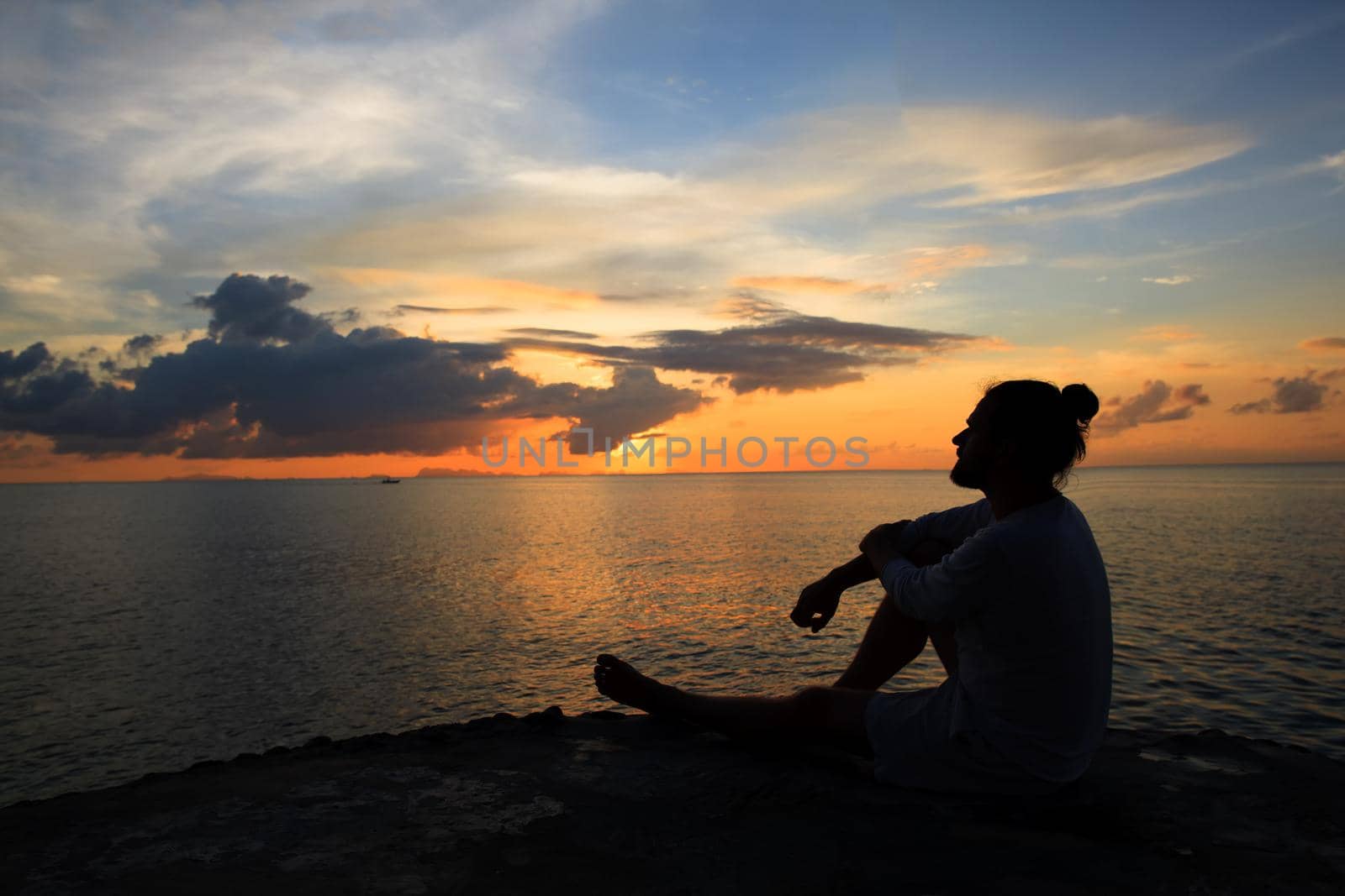 Yoga scene man silhouette in sunset background.