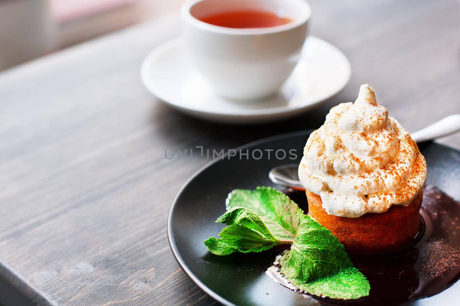 Breakfast time . Tea and cake with cream, garnished with mint leaves