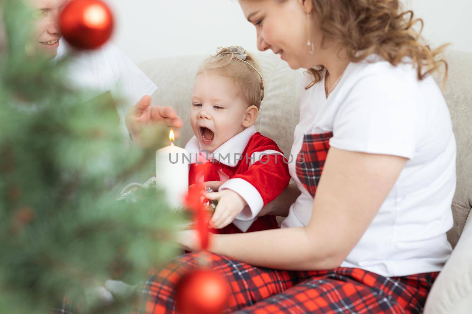 Baby child with hearing aid and cochlear implant having fun with parents in christmas room. Deaf , diversity and health concept by Satura86