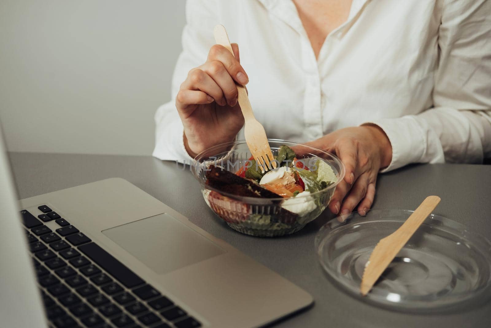 Unrecognisable Female Employee Having Lunch in Office, Woman Eating Salad at Working Place