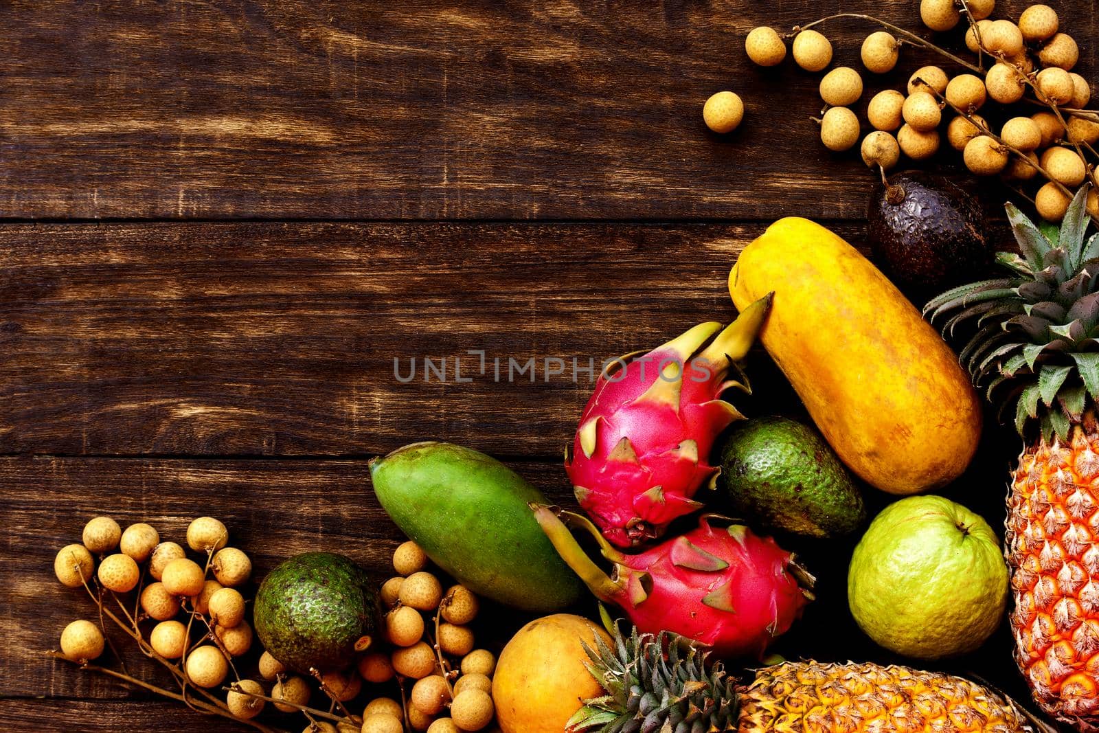 Fresh Tropical fruit on dark wooden background, top view