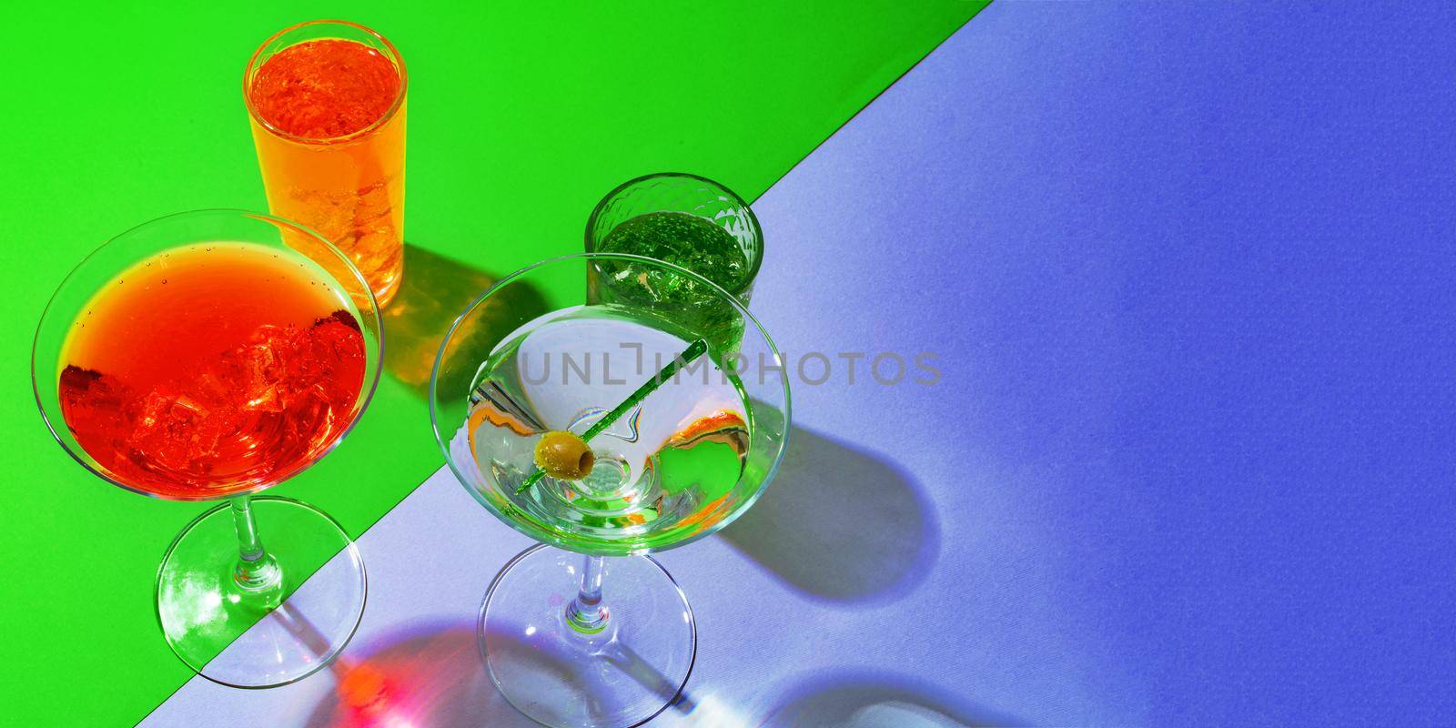 Cold and refreshing cocktails on color background, close up
