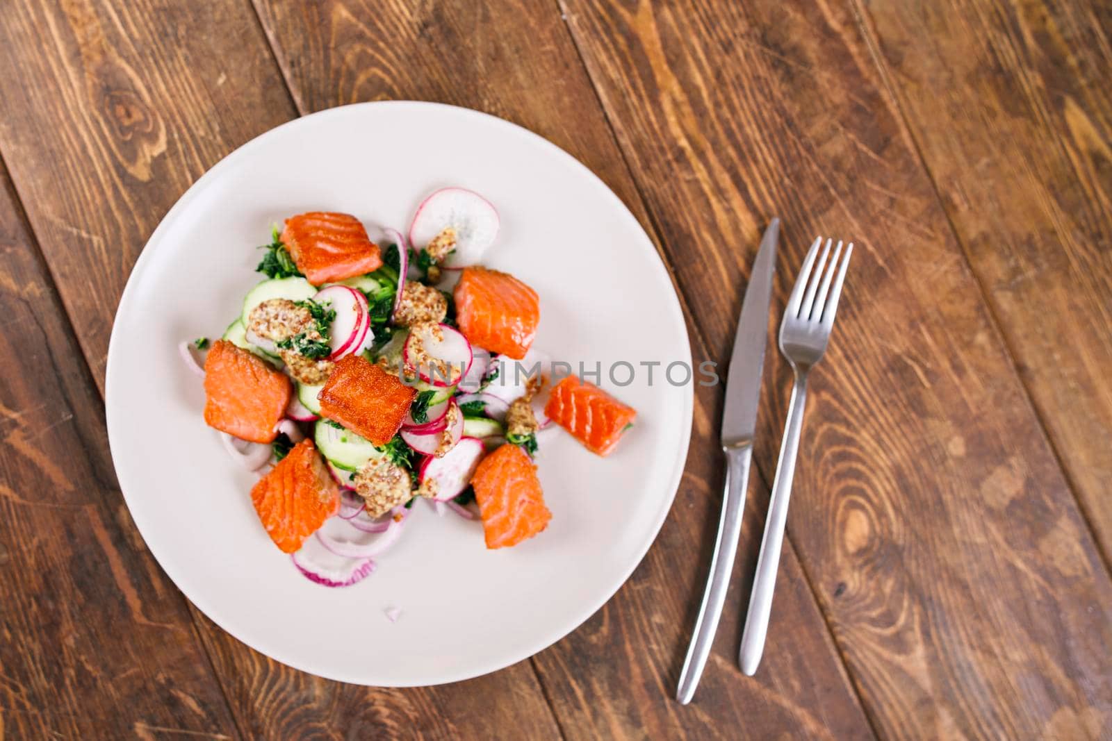 Grilled salmon with radish and spinach, served on white plate. View from above, top studio shot by Jyliana