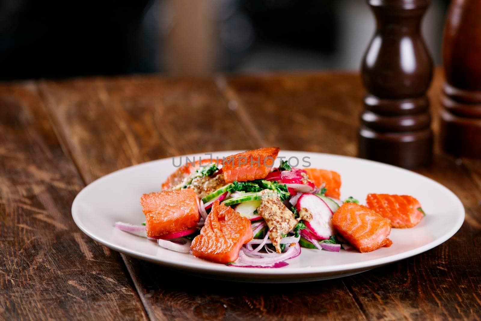 Grilled salmon with radish and spinach, served on white plate. View from above, top studio shot by Jyliana