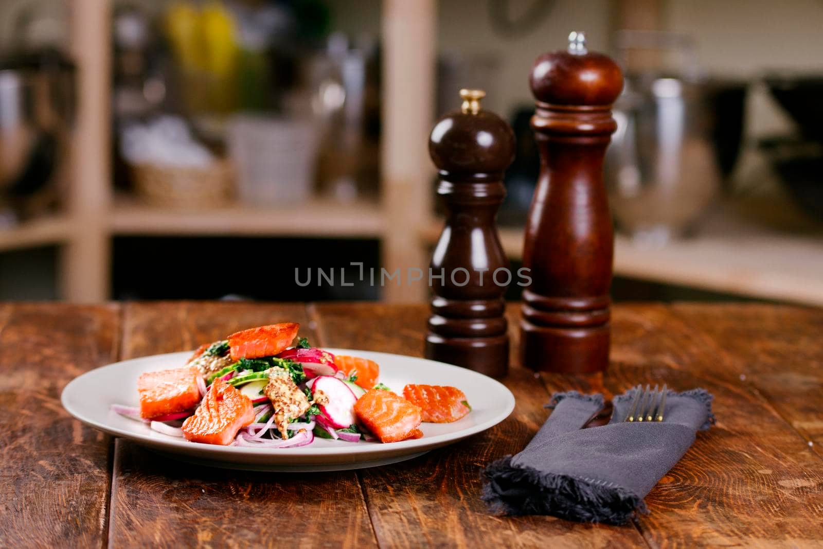 Red fish salmon with radish and spinach, served on white plate on wooden table. rustick style. View from above, top studio shot