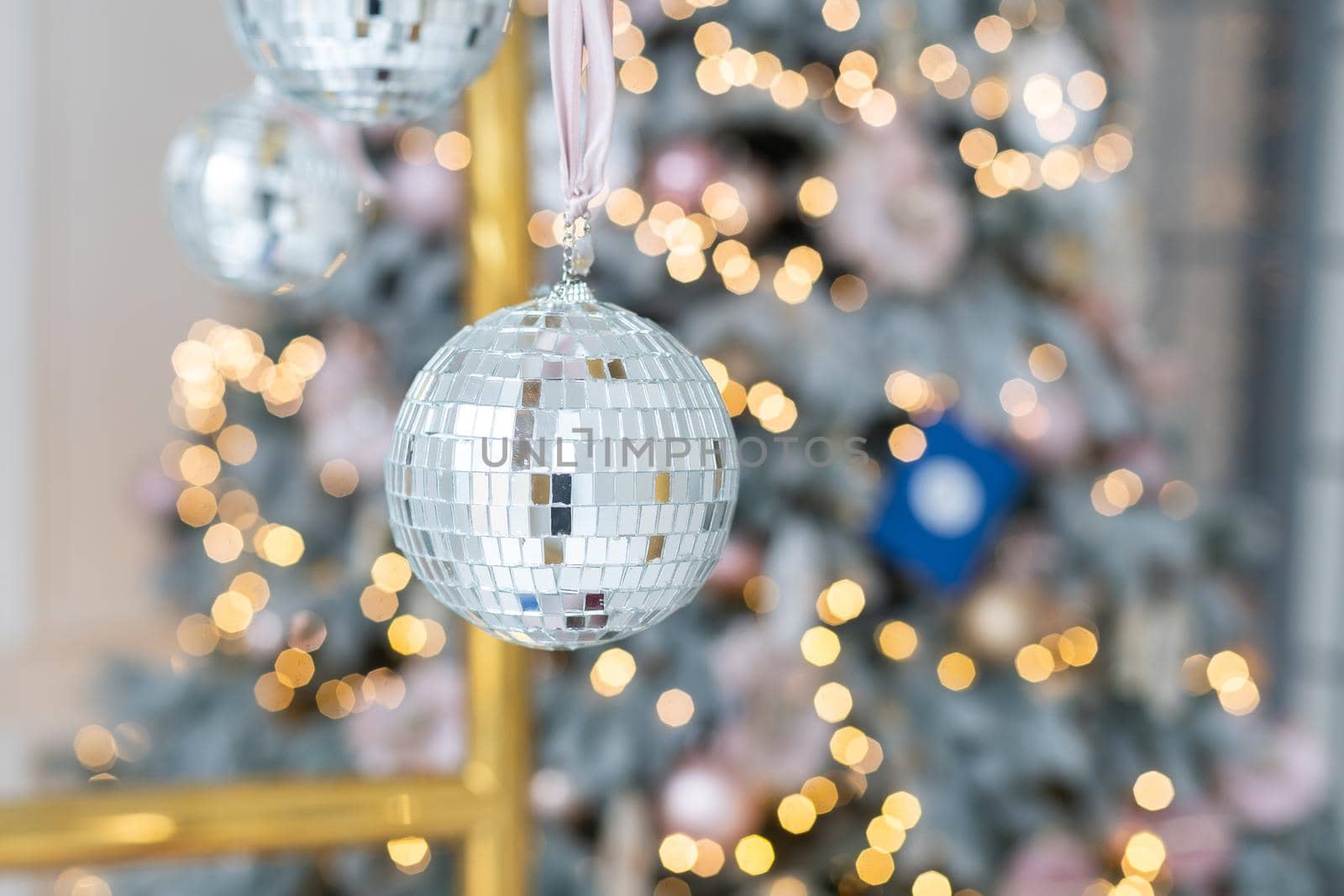 Closeup of Festively Decorated Christmas tree with bright balls on blurred sparkling fairy background. Defocused garland lights, Bokeh effect