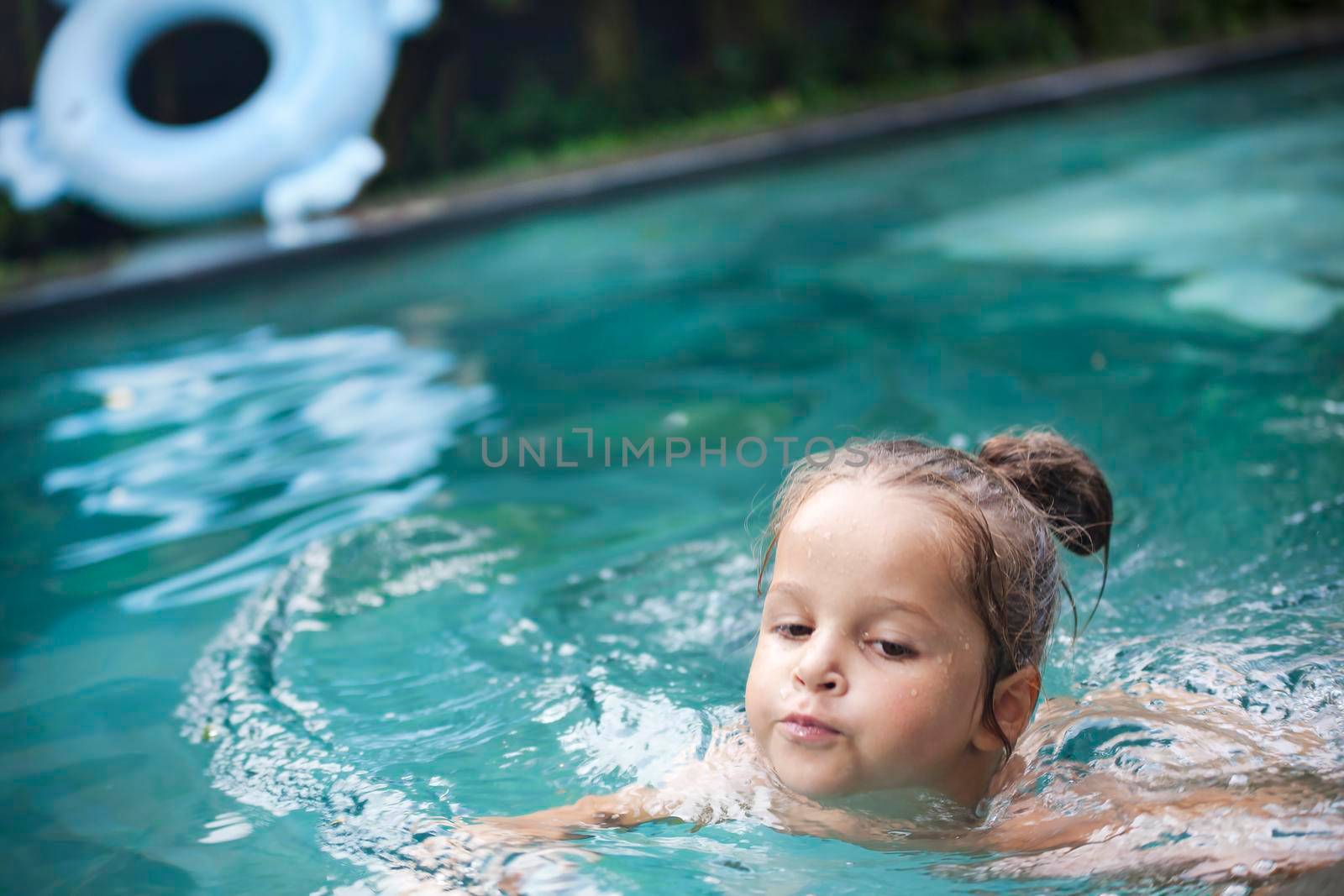 Happy Pretty little girl in swimming pool outdoor