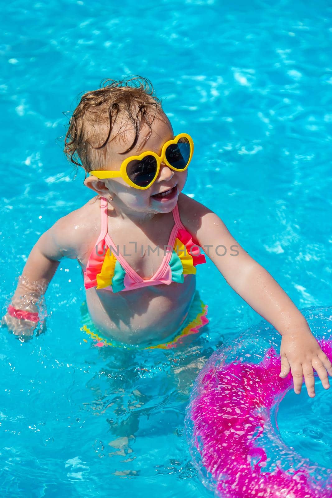 A child swims in a pool with a circle. Selection focus. Kid.