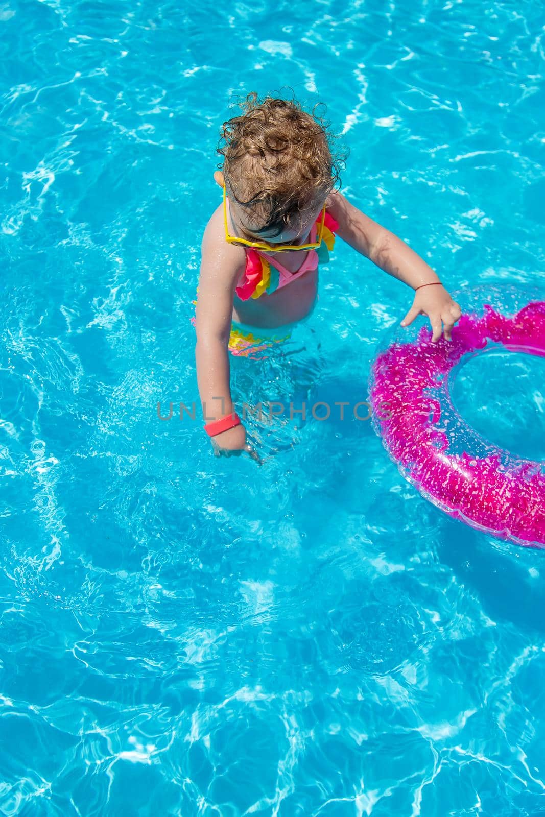 A child swims in a pool with a circle. Selection focus. Kid.
