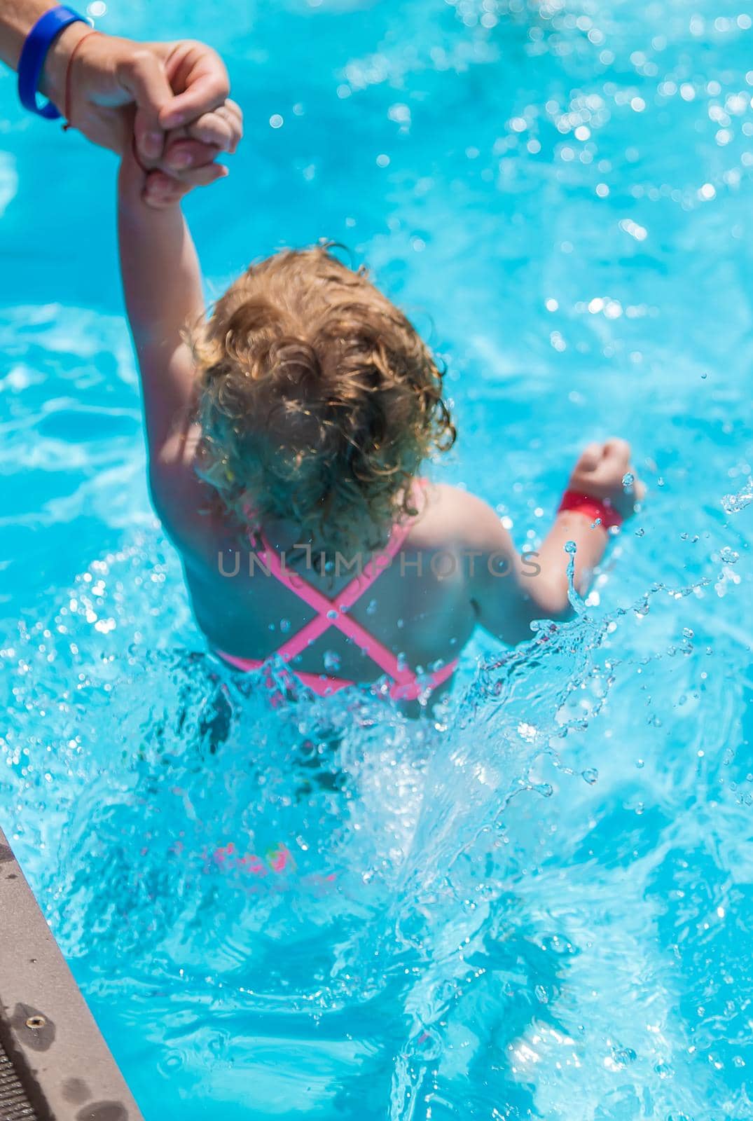 Baby swims in the pool. Selective focus. Child.