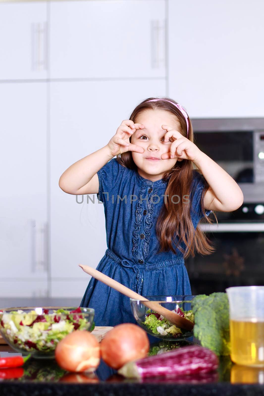 Sweet little cute girl indulges in the home modern kitchen, Family concept
