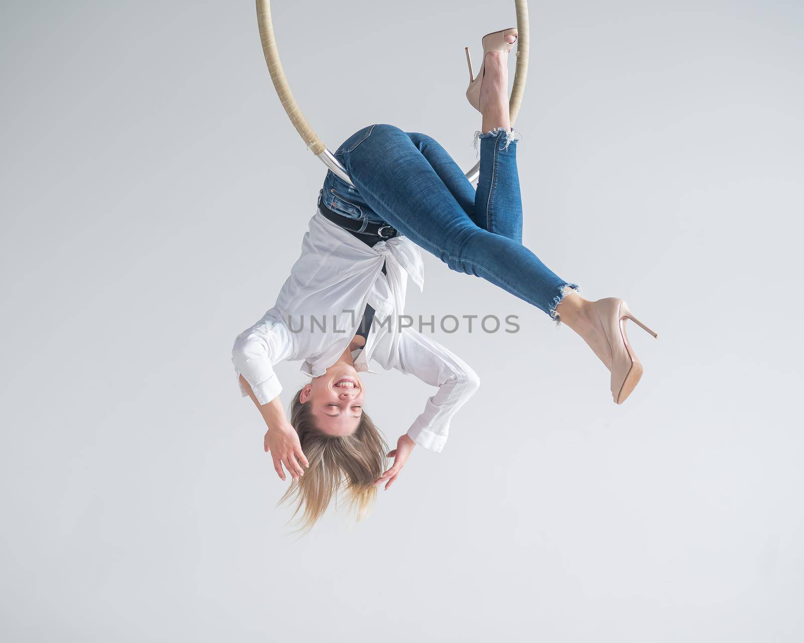 Caucasian woman in casual clothes on an aerial hoop. by mrwed54