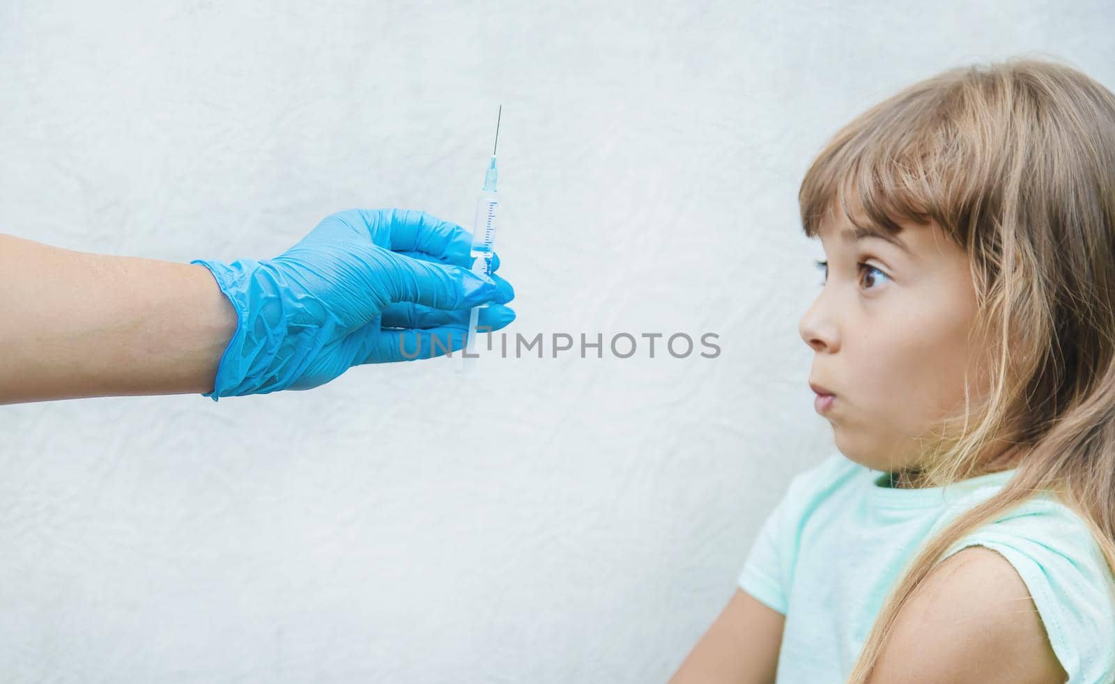 The doctor gives the child an injection in the arm. Selective focus.