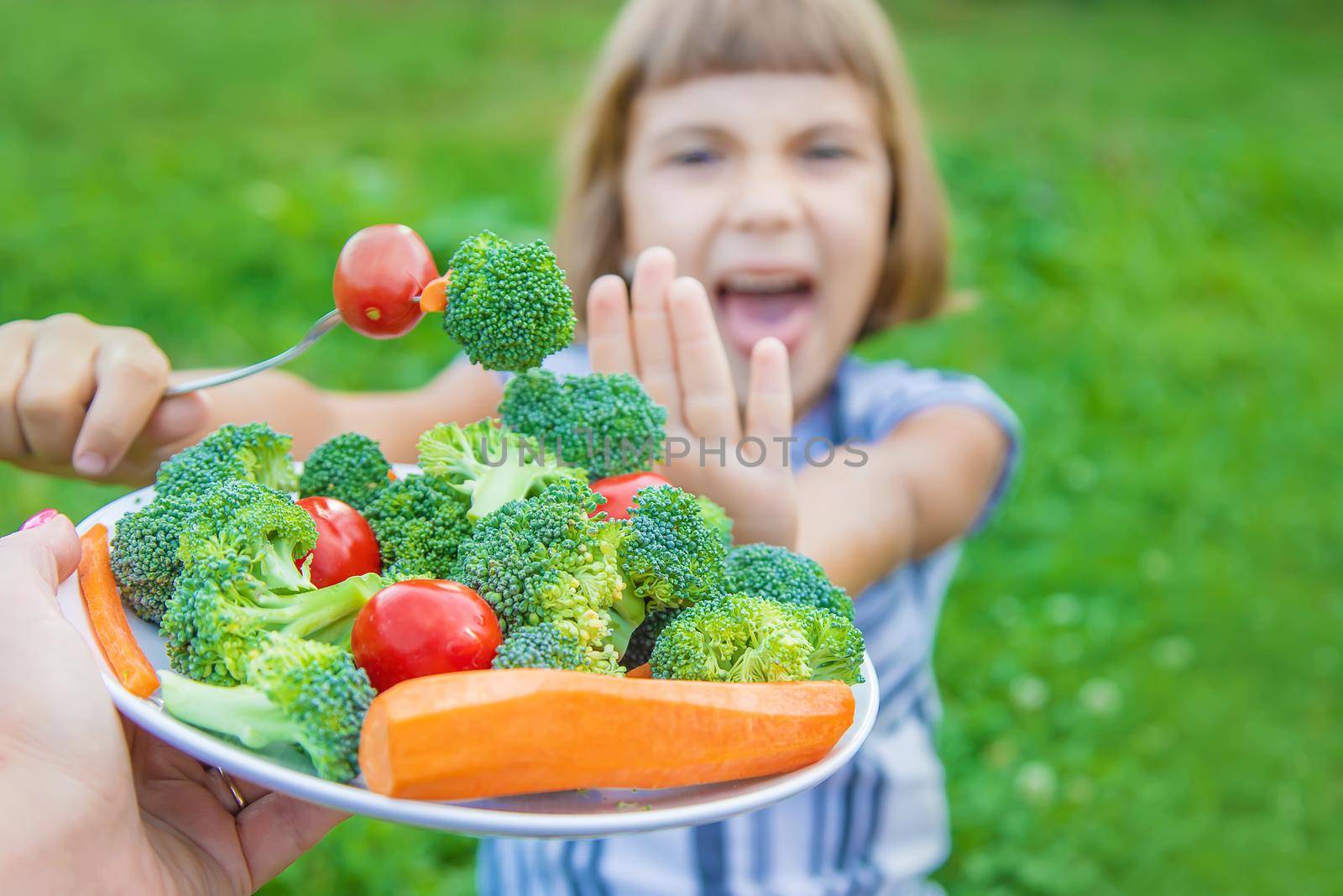 child eats vegetables broccoli and carrots. Selective focus.