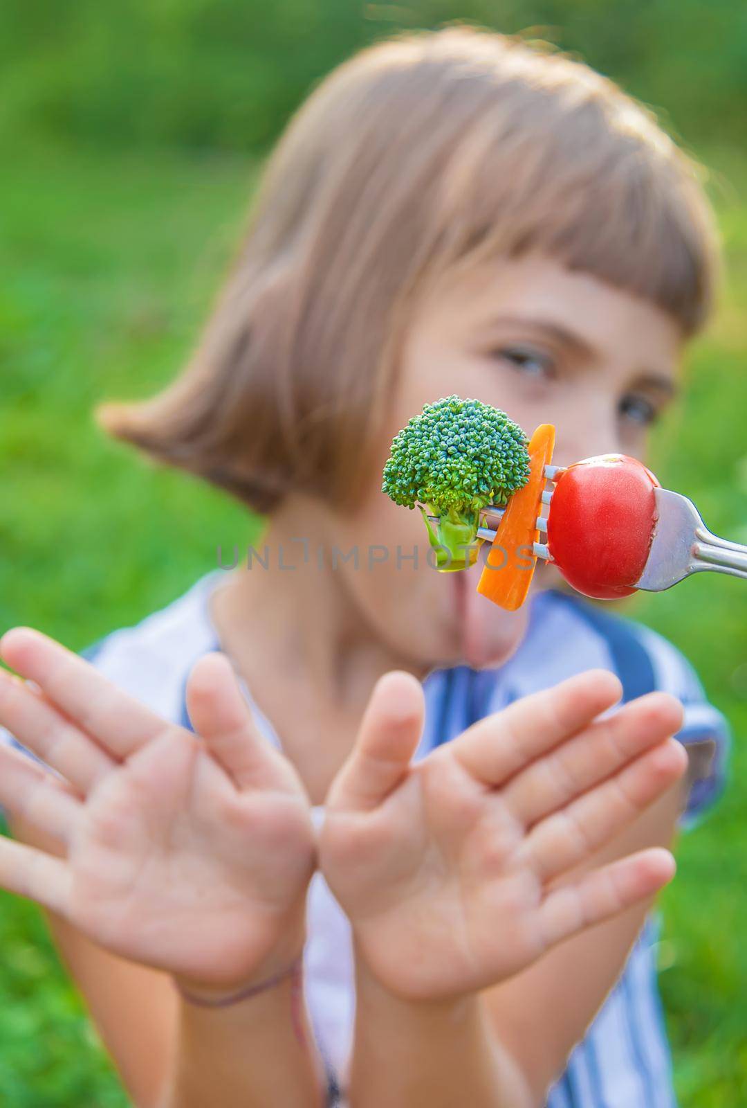 child eats vegetables broccoli and carrots. Selective focus.