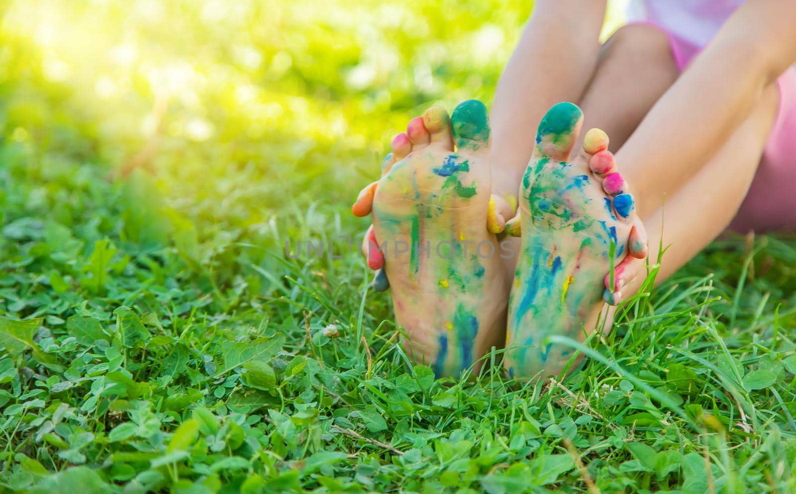 child with painted hands and legs. Selective focus. nature.