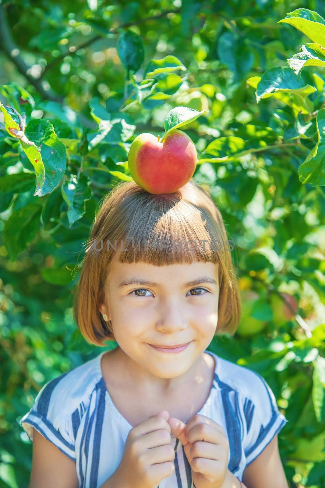 child with an apple in the garden. Selective focus. by yanadjana