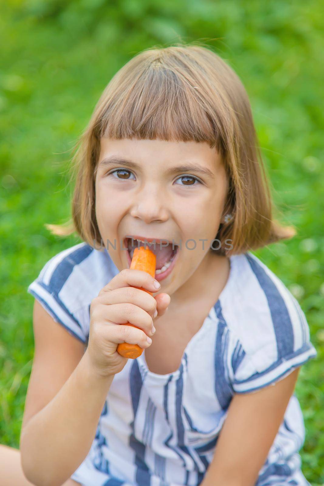 child eats vegetables carrots. Selective focus. food. by yanadjana