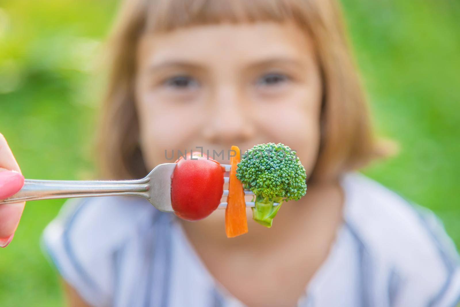 child eats vegetables broccoli and carrots. Selective focus. by yanadjana