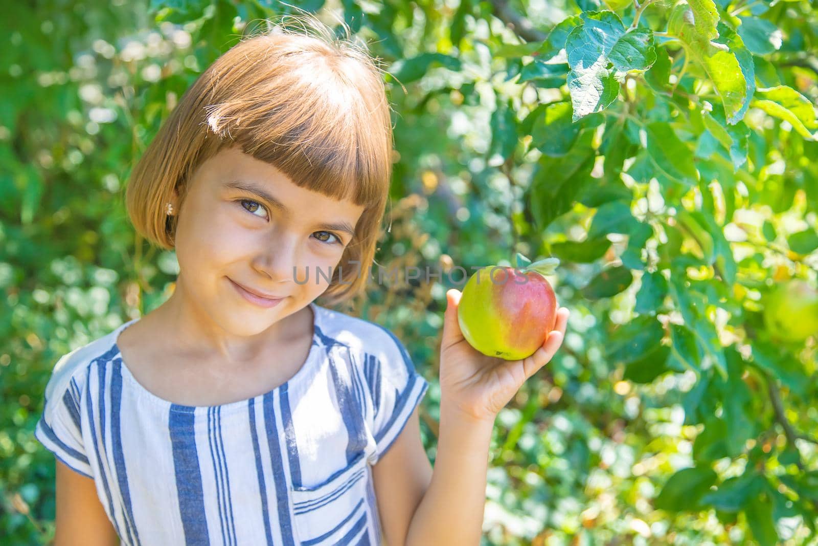 child with an apple in the garden. Selective focus.