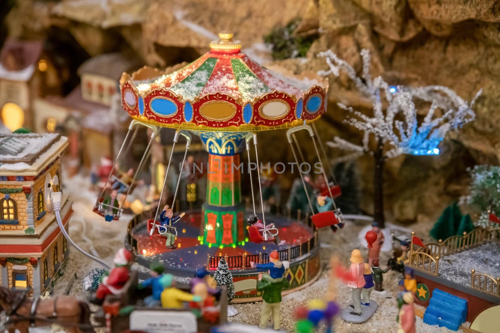 Amusement park in miniature with carousels in winter with figurines