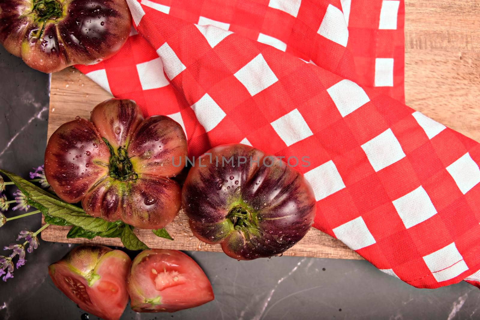 Fresh tomatoes in a plate on a dark background. Harvesting tomatoes. Top view