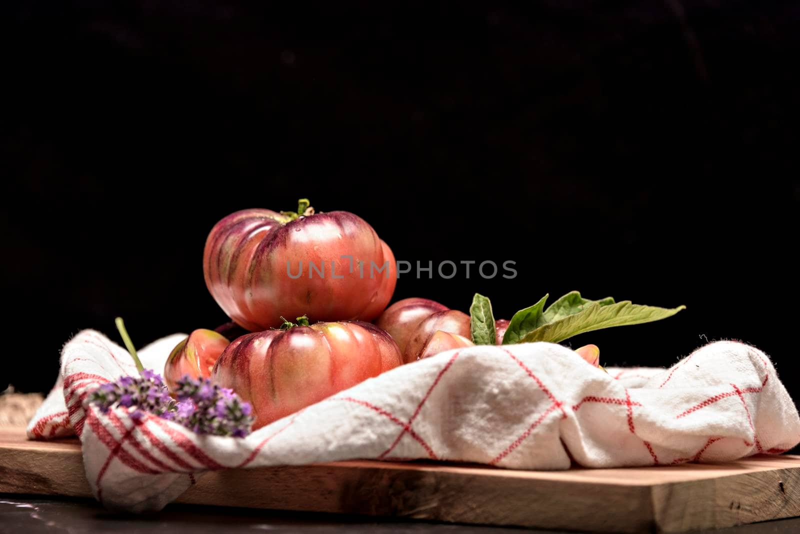 Beautiful fresh tiger tomatoes on dark background